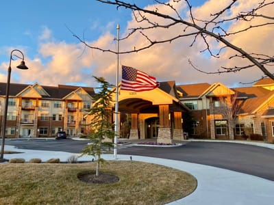 Exterior view of a senior living facility under a blue sky