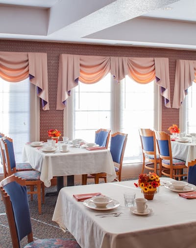 Dining area with neatly set tables and floral centerpieces