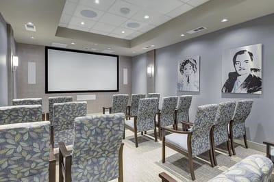 Interior activity room with seating and a projector screen