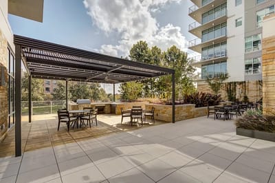 Outdoor seating area with shaded pergola and gardens