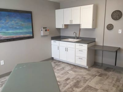 Interior view of a clinical space with cabinets and sink