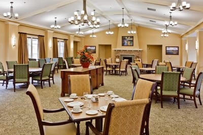Dining room area set for meals with tables and chairs
