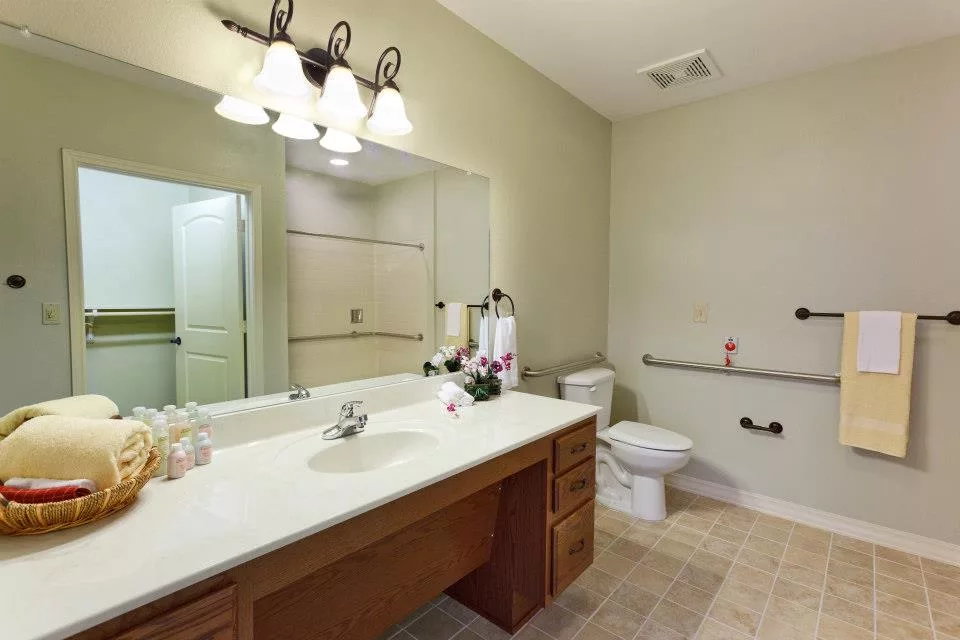 Bright bathroom with accessible features and floral arrangement