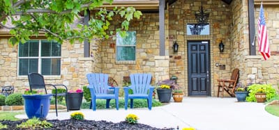 Entrance to a senior living facility with seating and landscaping