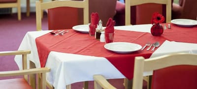 Dining table setup with red napkins and decorations