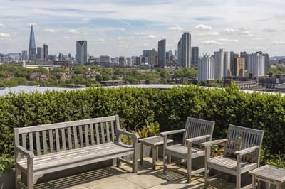 Outdoor seating area with city view and greenery