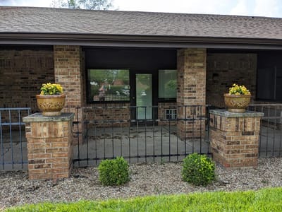 Exterior view of the facility entrance with flower pots