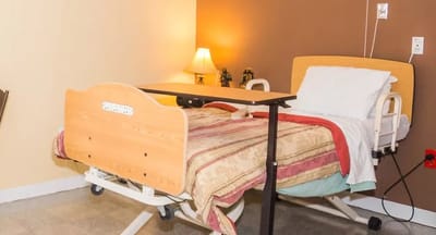 Interior of a resident room with hospital bed and lamp
