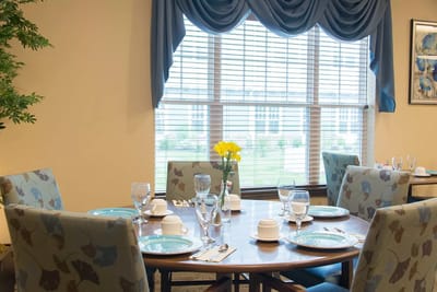 Dining room setup with dishes and flowers.