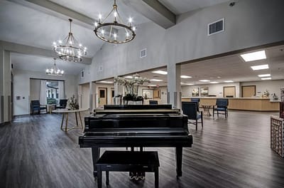 Spacious interior common area with a piano and elegant lighting