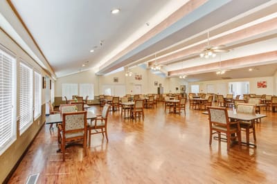 Dining room with tables and chairs arranged for residents