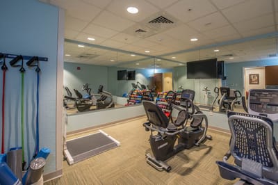 Well-equipped fitness room with exercise machines and weights