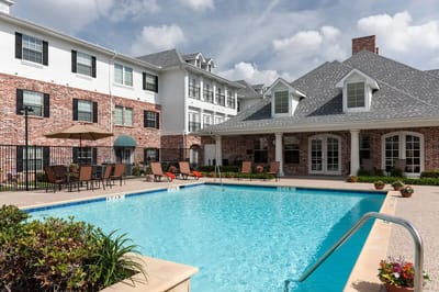 Outdoor pool area with lounge chairs and building in background