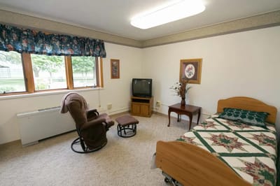 Cozy resident room with a single bed and chair