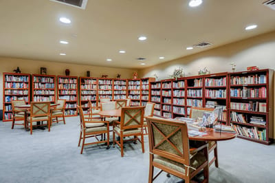 Interior view of a well-stocked library with tables and chairs
