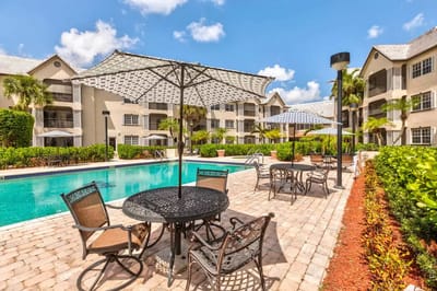 Outdoor pool area with seating and umbrellas
