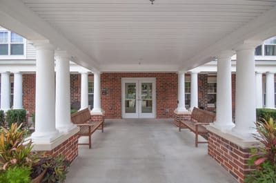 Entrance to Victory Court Senior Apartments with benches and plants