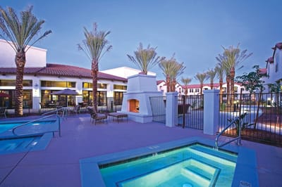 Outdoor pool area with palm trees and seating