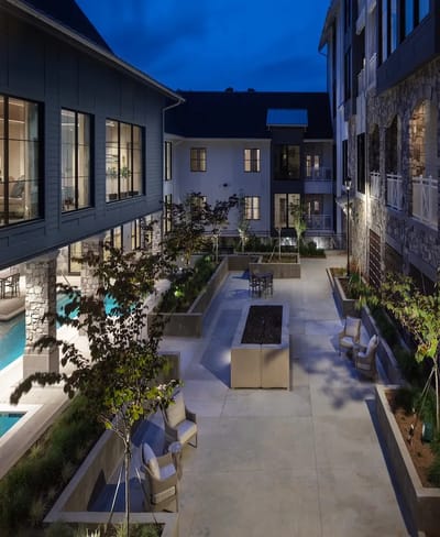 Outdoor courtyard with seating and landscaping at night