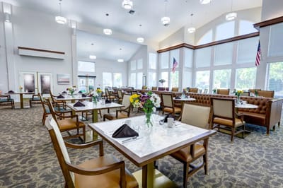 Dining area with tables set for meals and floral arrangements