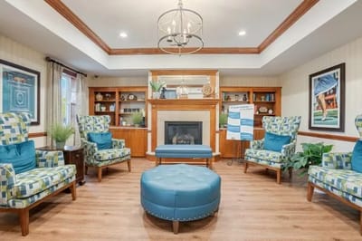 Bright common area with blue chairs and a fireplace