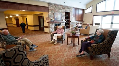 Residents relaxing in a common area with fireplace
