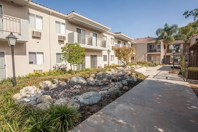 Outdoor pathway with landscaping and building in background