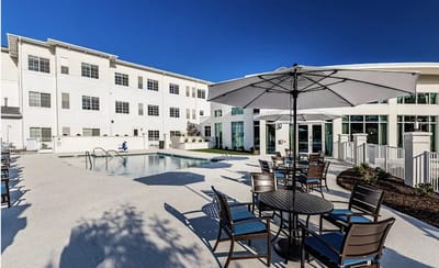 Outdoor pool area with seating at Vitality Living Columbia