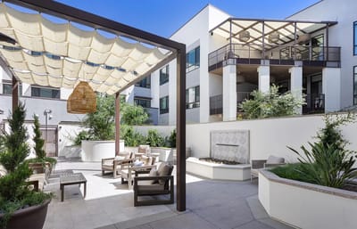 Outdoor seating area with greenery and a fountain