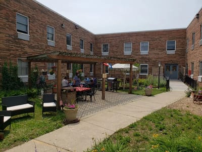 Residents enjoying an outdoor space with seating and tables