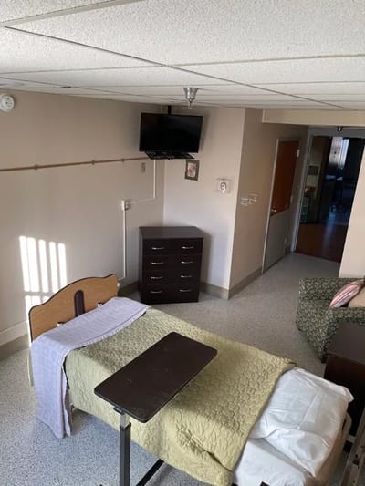 Interior view of a resident room with a bed and television