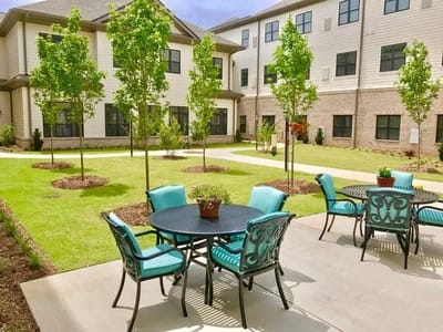 Outdoor seating area with tables and greenery