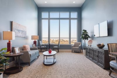 Bright common area with large windows and cozy seating