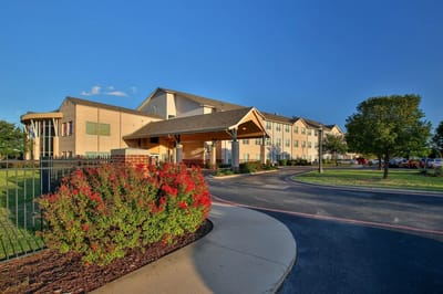 Exterior view of Wesley Court Senior Living facility with landscaping