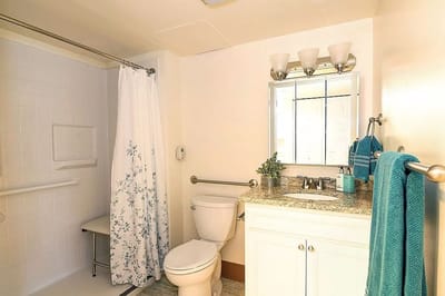 A well-lit bathroom with a shower and sink