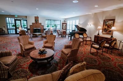 A cozy common area with seating and a piano