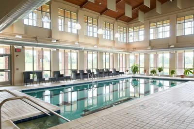 Indoor pool area with lounge seating and large windows