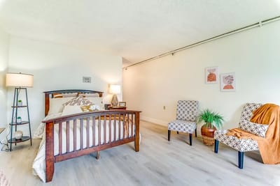 Bright, well-decorated resident room with bed and seating area
