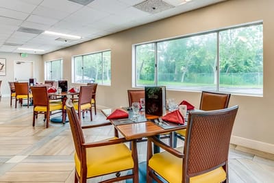 A brightly lit dining room with tables set for meals