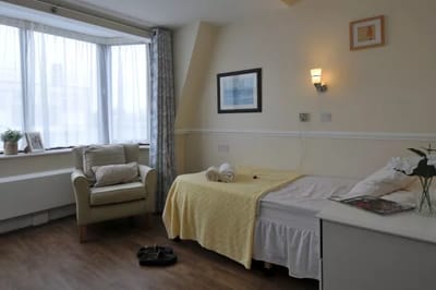 Cozy private room with a bed and armchair
