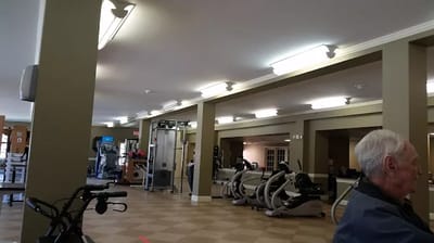 Residents using exercise equipment in a fitness area