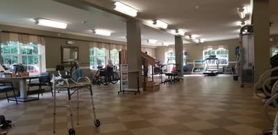 Interior view of an activity room with residents and exercise equipment