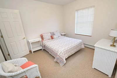 Brightly furnished private resident room with a bed and chair