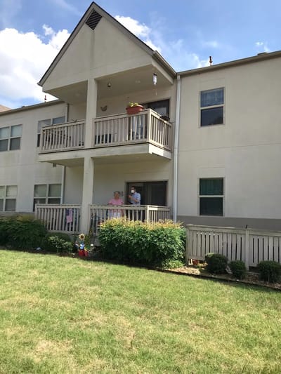 Residents on a balcony of the facility building
