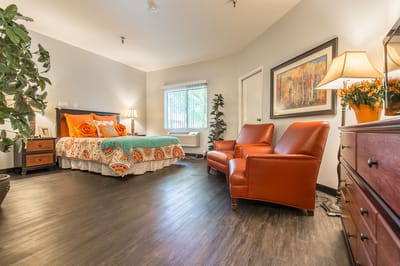 Brightly decorated resident room with a bed and seating area