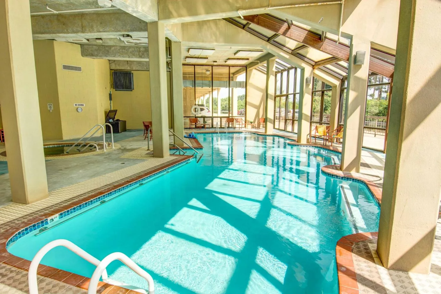 Indoor pool area with large windows and sunlight