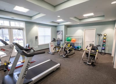 A fitness room with exercise equipment and therapy balls