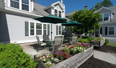 Outdoor seating area with flower beds and umbrellas