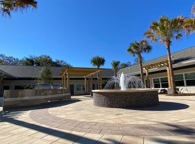 Outdoor courtyard with a fountain and palm trees