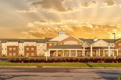 Front view of a senior living facility with sunset